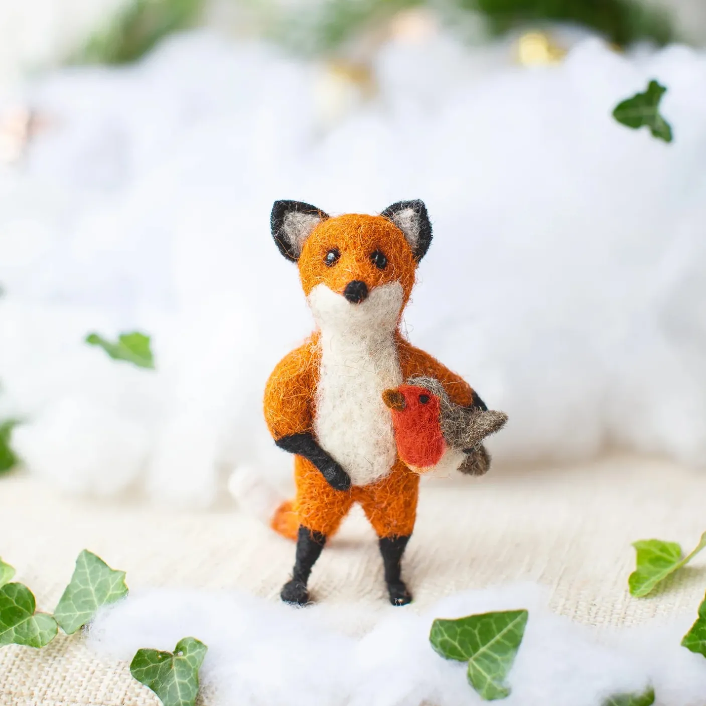 Hunter Fox Holding Holding a Robin Felt Decoration